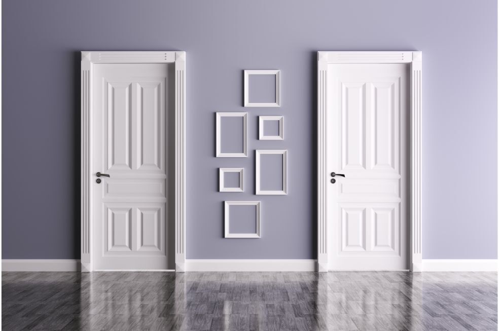 para białych drzwi wewnętrznych na fioletowej ścianie z białymi ramkami