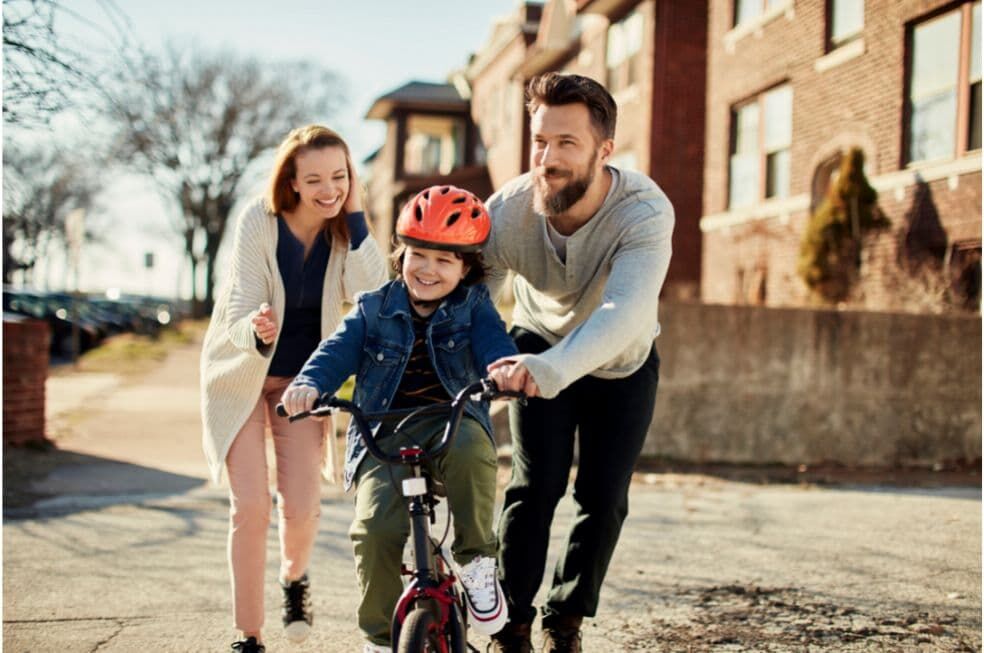 rodzice uczący dziecko jazdy na rowerze