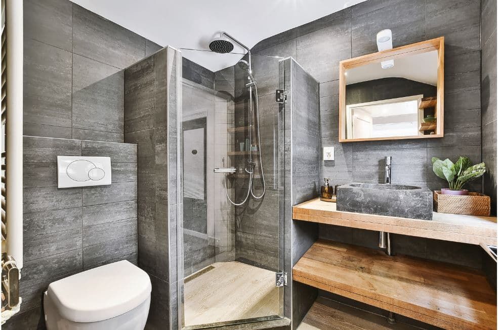 nowoczesna łazienka z prysznicem walk in z szarymi płytkami i drewnem