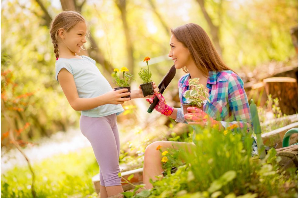 córka z mamą w ogródku sadzą kwiatki