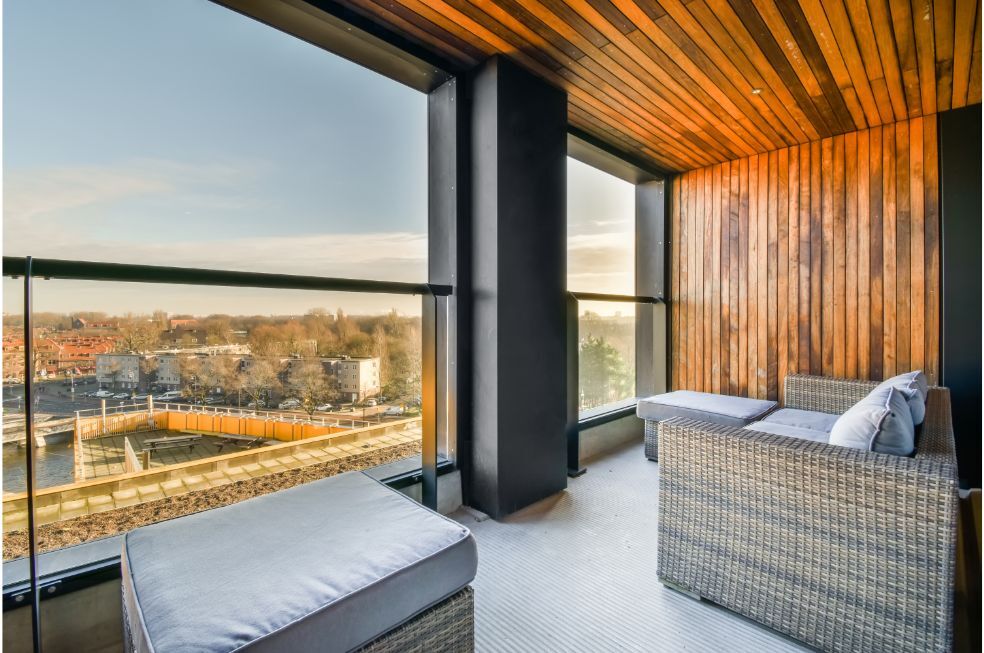balkon obłożony drewnem z meblami z rattanu w jesiennych odcieniach