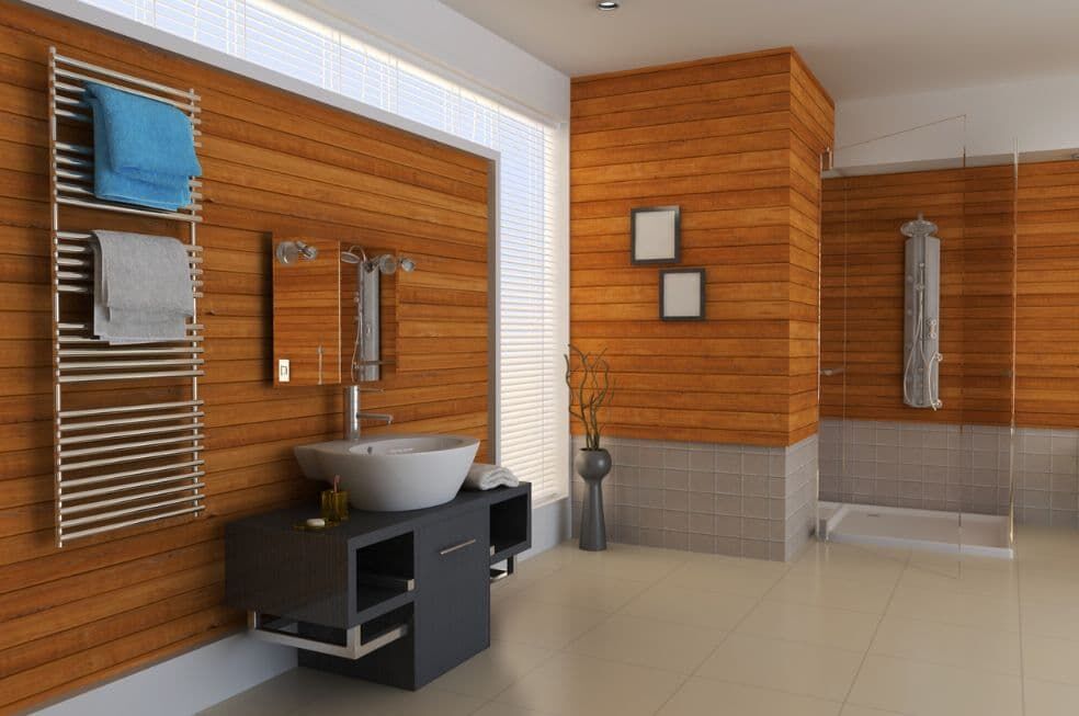 łazienka wyłożona drewnem na ścianie, z przeszklonym prysznicem i grzejnikiem drabinkowym na ścianie