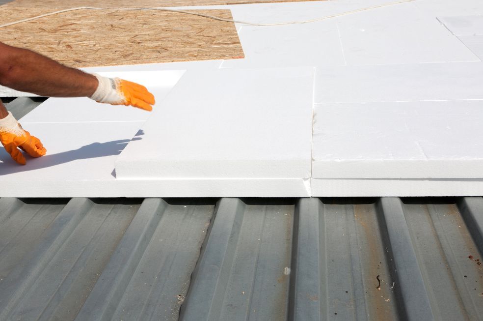 mężczyzna wykładający blachę styropianem