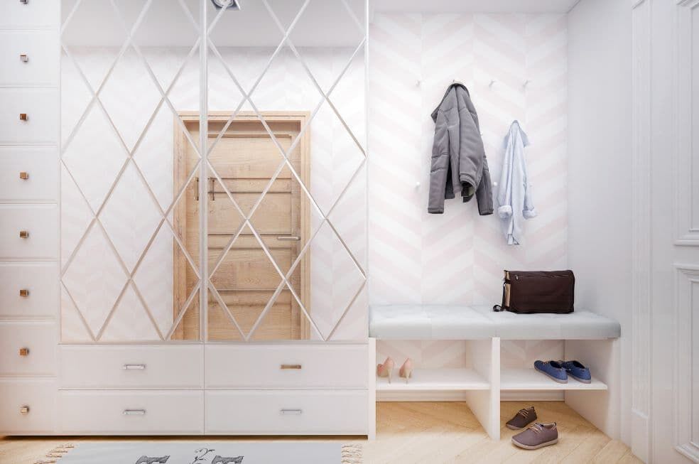 jasny przedpokój z białą szafą koło drzwi