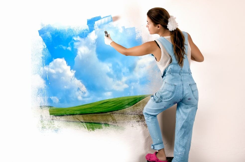 kobieta malująca krajobraz na ścianie