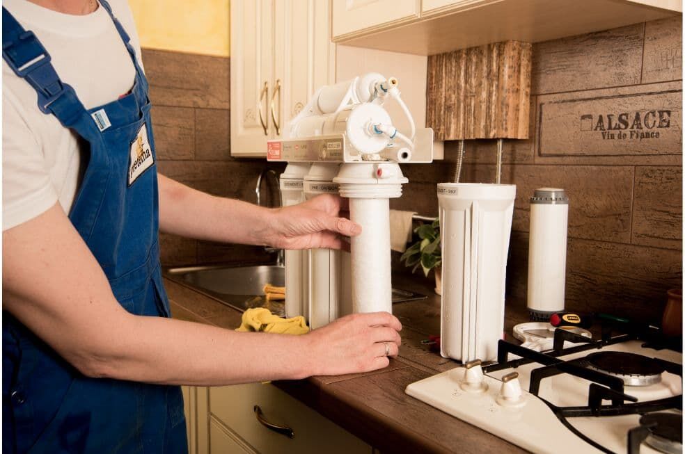 mężczyzna wymieniający filtry do wody