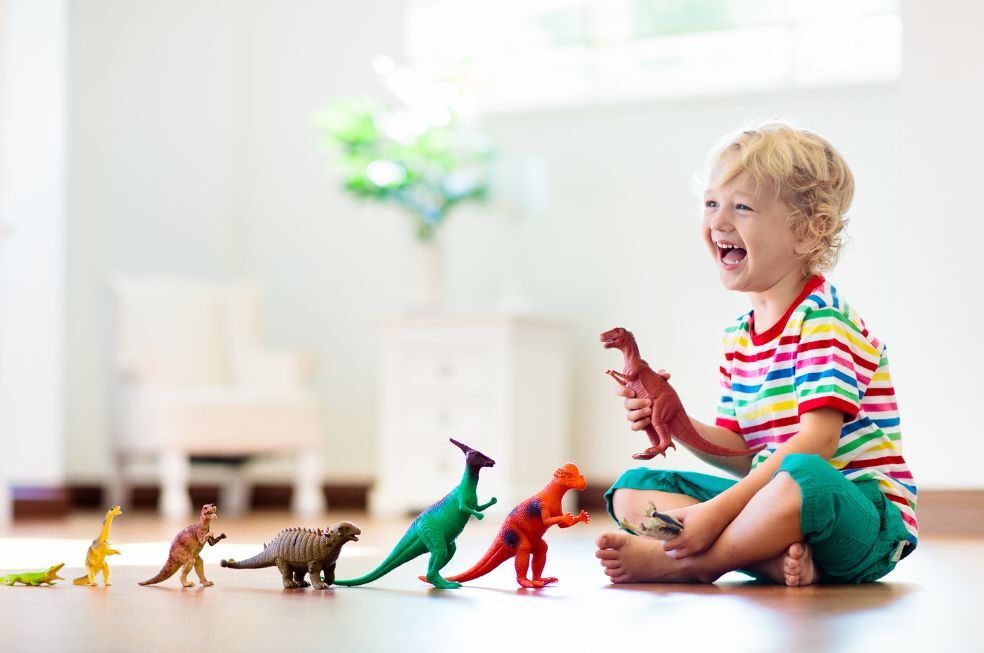 chłopczyk bawiący się gumowymi zabawkami na podłodze