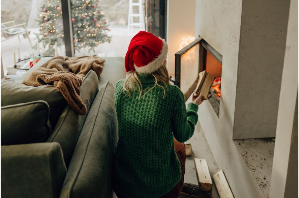 kobieta rozpalająca ogień w kominku