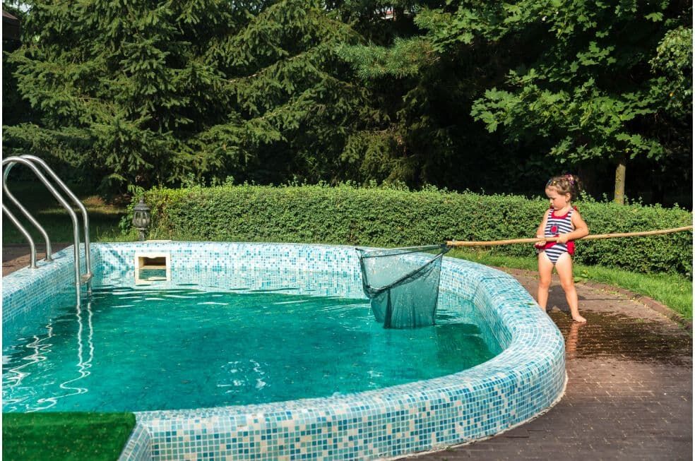 dziewczynka czyszcząca basen sitkiem