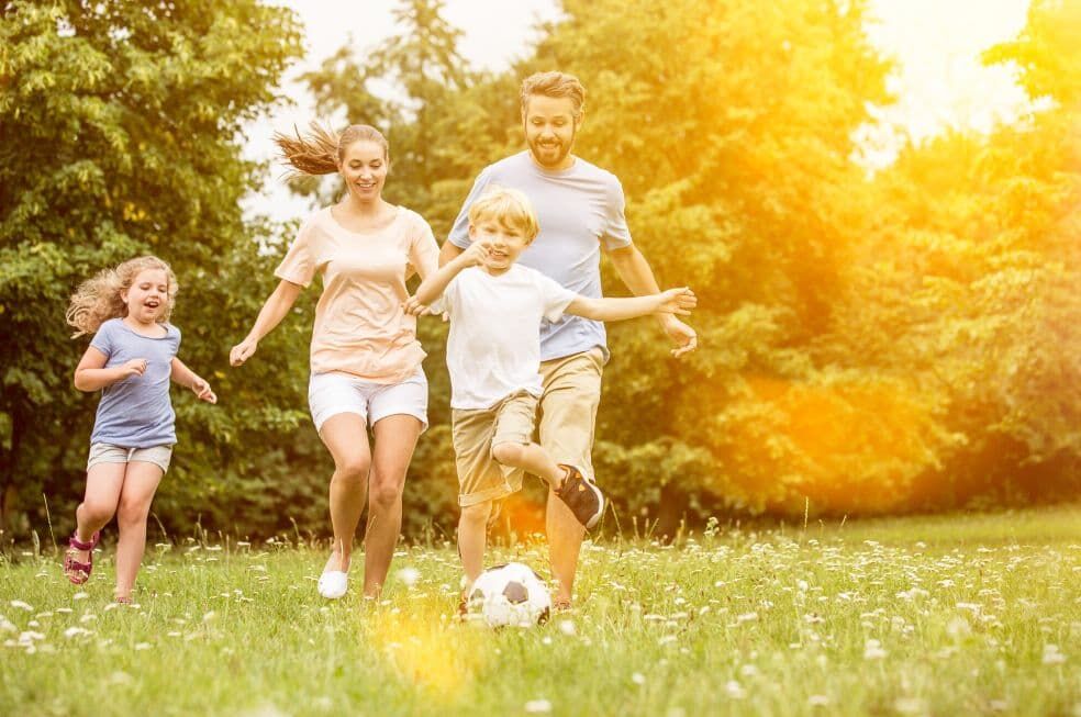 rodzina grająca w piłkę nożną na dworze