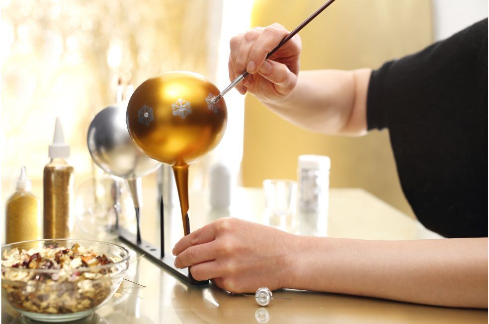 kobieta malująca bombki na choinkę