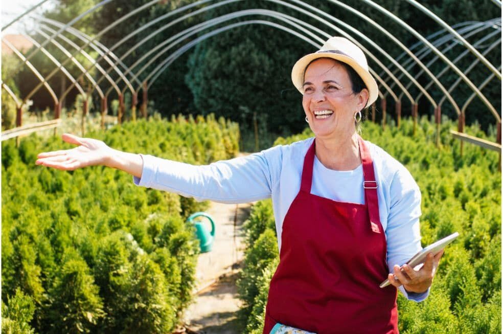 pani ogrodnik w swojej szkółce z drzewkami